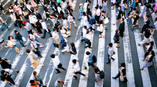 Viele Menschen laufen über eine Straße