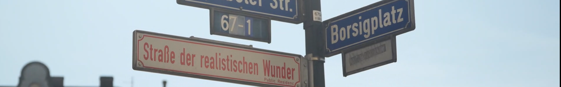 Straßenschild am Borsigplatz in Dortmund zeigt die Straßen "Wambeler Str." und "Borsigplatz" und das Zusatzschild "Straße der realistischen Wunder".