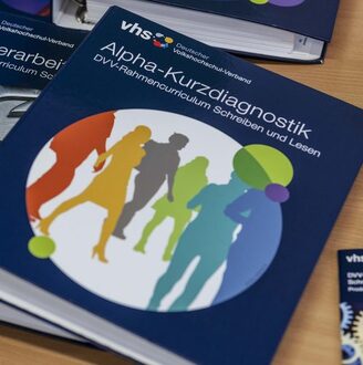 Liegender Aktenordner mit der Beschriftung „Alpha-Kurzdiagnostik – DVV-Rahmencurriculum Schreiben und Lesen“