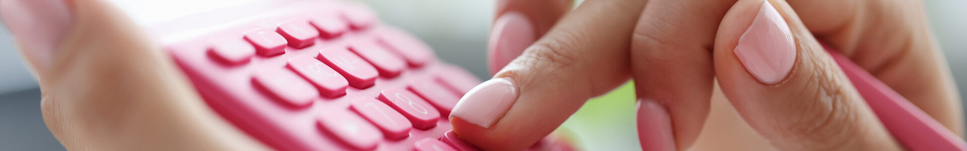 Rechnen lernen mit dem Taschenrechner: Nahaufnahme einer Hand, die an einem pinkfarbenen Taschenrechner tippt und einen gleichfarbigen Stift hält.