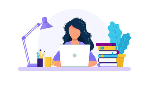 Eine Frau sitzt an einem Laptop mit dem Gesicht zum Betrachter. Auf dem Schreibtisch zu sehen sind eine Lampe, ein Stiftebecher, eine Pflanze und ein Bücherstapel.