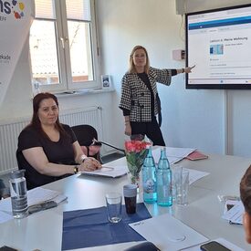 Die Kursleiterin steht am Smartboard und erklärt eine Übung im vhs-Lernportal.