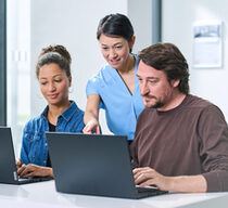 Drei Menschen schauen auf Laptops